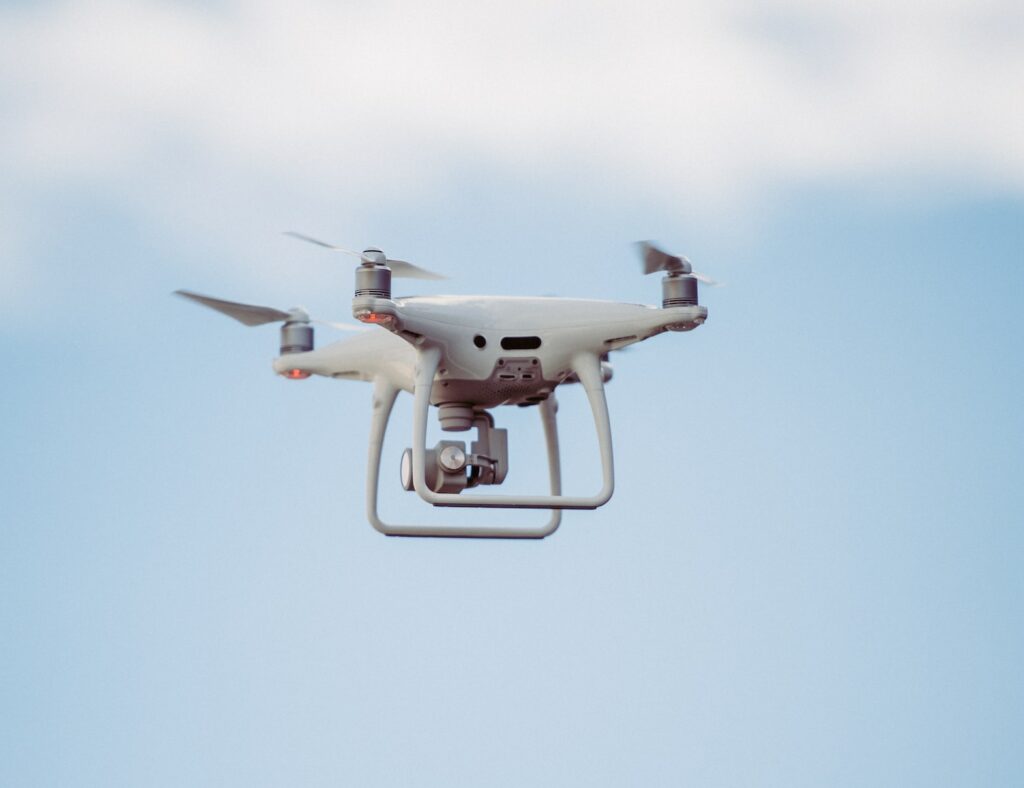 white DJI drone in mid air